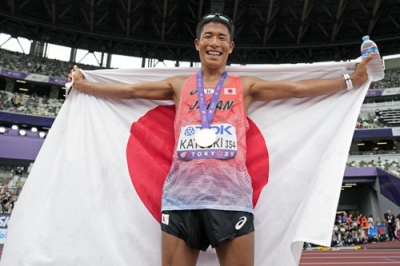 写真:陸上の第20回世界選手権東京大会の男子35キロ競歩で銅メダルを獲得し、日の丸を掲げる勝木隼人=13日、東京・国立競技場