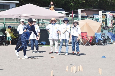 写真:狙いのスキットルめがけモルックを投げる参加者