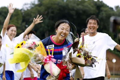 写真:引退セレモニーで笑顔を見せる永里優季さん。左は妹亜紗乃さん、右は兄源気さん=神奈川県厚木市