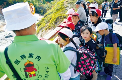 写真:観光ボランティアガイドの話を聞く子どもたち