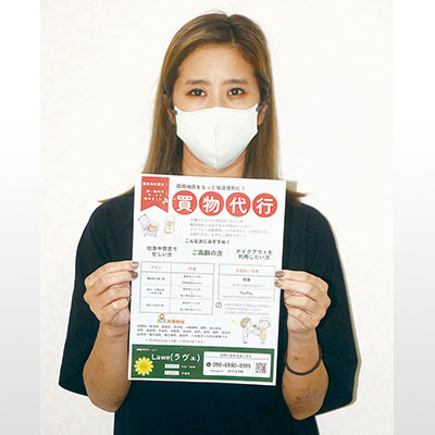 写真:ポスターを手に利用を呼びかける買い物代行サービス「Lawe(ラヴェ)」代表の紙谷さん
