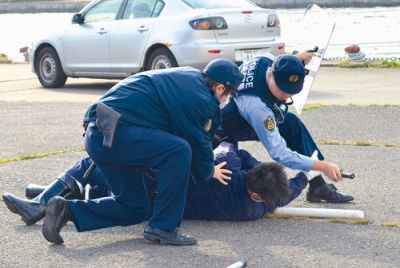 写真:逃走するテロリスト役を制圧する海保職員と警察官