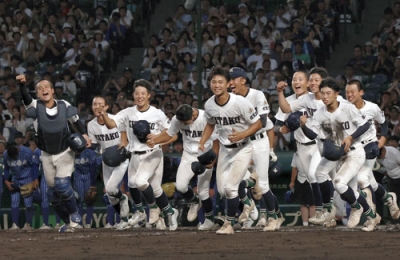 写真:今夏の全国高校野球選手権大会で勝利し駆け出す佐賀県立佐賀北高の選手たち=8月、甲子園球場