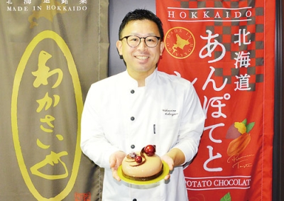 写真:入賞作品を持つ松澤さん