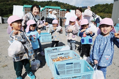 写真:袋いっぱいの「えったま」に笑顔を見せる子どもたち