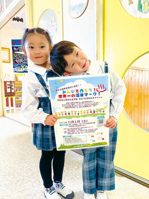 写真:参加を呼びかけるポスターを持つ園児