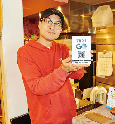 写真:タクシー配車アプリ「GO」のポップを持つ大阪代表