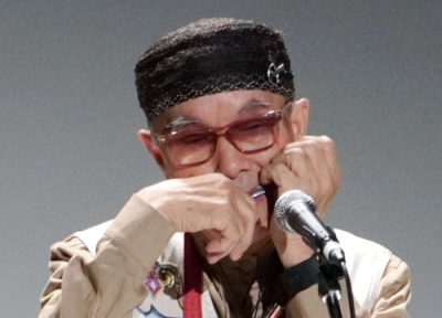 写真:口琴の国際大会の開会式で演奏する奏者=24日午前、釧路市の阿寒湖アイヌコタン
