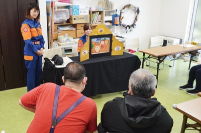 写真:施設利用者に紙芝居を披露する女性分団員