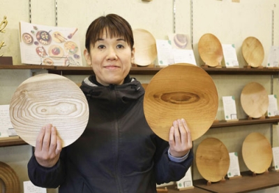写真:里山の木で作られた皿を手に持つ木工クラフト工房「チエモク」の三島千枝社長=札幌市