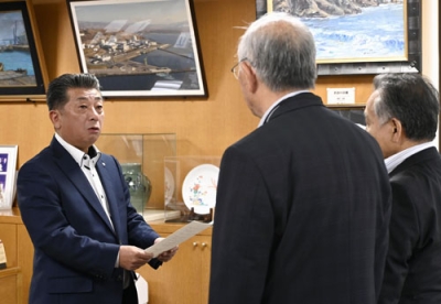 写真:泊村議会の議長らから意見書を受け取る高橋鉄徳村長(左)=31日午前、泊村