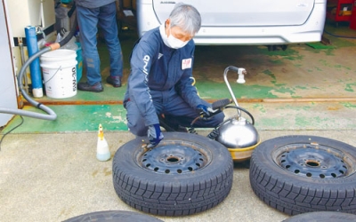 写真:冬タイヤの空気圧を確かめる北海石油室蘭給油所のスタッフ