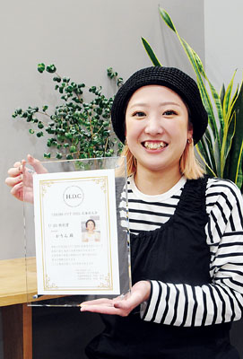 写真:北海道大会U25特別賞の盾を手に笑顔を見せる橋本さん