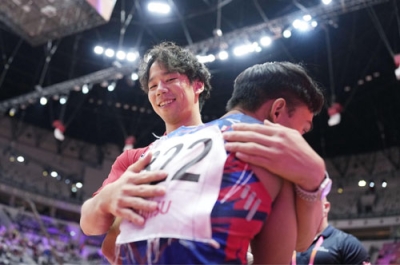 写真:体操の世界選手権、男子種目別床運動の決勝で、演技を終えたタイのスリントルタ・ティクポーン(手前)を抱きしめる中谷至希さん=10月、ジャカルタ(共同)