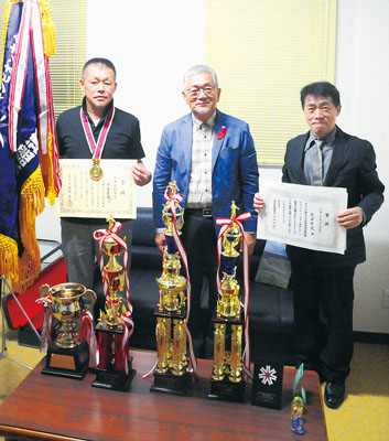 写真:グランドチャンピオン大会で好成績を残した松浦さん(左)と林さん(右)。中央は橋本会長