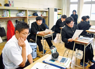 写真:ネット広告を見比べ、潜むリスクを話し合う生徒たち