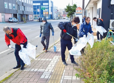 写真:道路のごみを丁寧に拾い集める参加者
