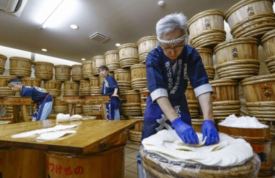 写真:京都市左京区の老舗漬物店「大安」で公開された「千枚漬」の漬け込み作業=7日午前