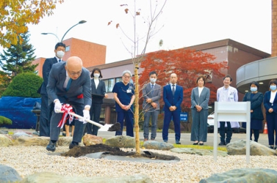 写真:60周年を記念してヤマボウシの苗を植樹する千葉院長