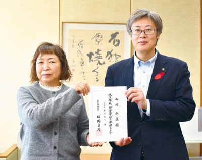 写真:民生委員児童委員の委嘱状を受けた西川さん(左)