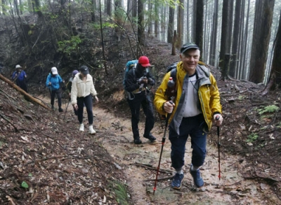 写真:熊野古道を案内するティム・デットマーさん(手前)=9月、和歌山県高野町