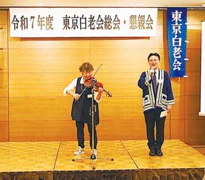 写真:あいさつする大塩町長(右)。左は白老町観光大使のバイオリニスト・牧千恵子さん(提供写真)