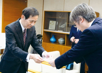 写真:目録を手渡す今井代表取締役(左)