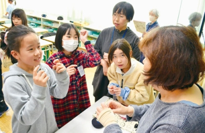 写真:宮武さん(右)の指導を受けながら手話を練習する児童たち