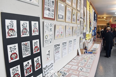 写真:心温まるメッセージやイラストが並ぶ己書作品展