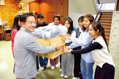 写真:市民有志から寄贈された冬服を受け取る留学生たち