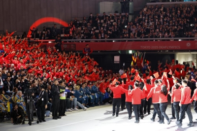 写真:「東京デフリンピック」の開会式で、入場する選手らを見守る日本選手団(左)=15日、東京体育館