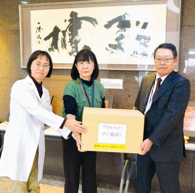 写真:長橋理事長(右)らから善意を受け取る鴨井施設長(左)=プライムヘルシータウン湘南