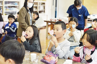 写真:手鏡を使って丁寧に歯を磨く一年生たち