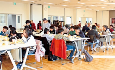 写真:会話を楽しみながら料理を味わう子どもや地域住民たち