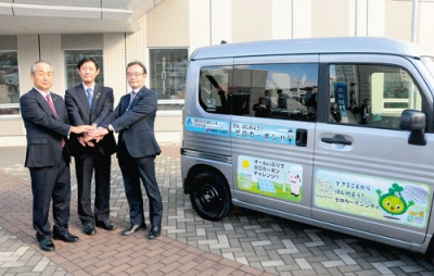 写真:カーシェアリングする車両の横で握手する(左から)中田会頭、青山市長、牧野局長