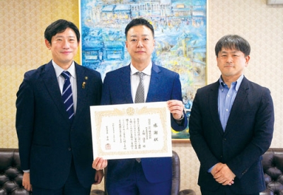 写真:青山市長(左)から感謝状を受け取った上村社長(中央)