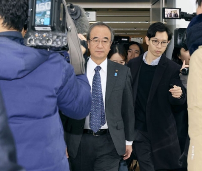 写真:記者団に囲まれながら新潟県庁に登庁する花角英世知事(左)=21日午前