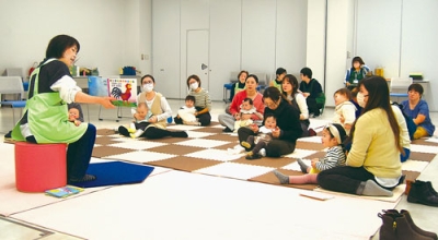 写真:絵本の読み聞かせを楽しむ親子ら