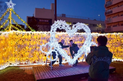 写真:ハート型のイルミネーションと共に記念撮影する高校生たち=29日午後4時半ごろ