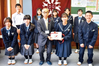 写真:菊池会長(前列左から3番目)に募金箱を手渡す伊達中生徒会メンバー