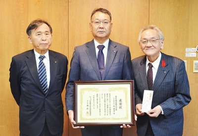 写真:寄付の感謝状を受け取った昆社長(中央)と松本技術部長(左)