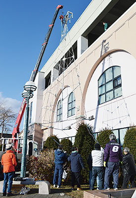 写真:クレーンでツリー型のイルミネーションを設置する関係者ら