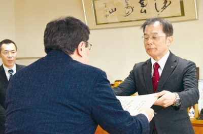 写真:小笠原市長から感謝状を受け取る平井代表取締役社長(右)