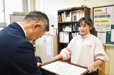 写真:社明運動作文コンテストの表彰状を受け取る安川さん