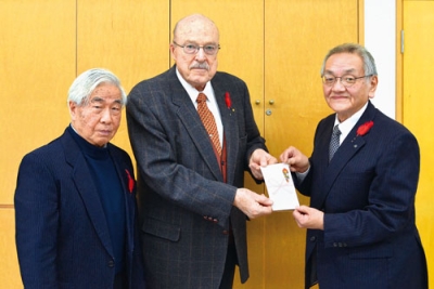 写真:ライヤ・フランシス主任司祭(中央)と運営委員長の松岡健一さん(左)から目録を受け取る國枝信会長
