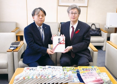 写真:堀井市長に目録を手渡す松川取締役