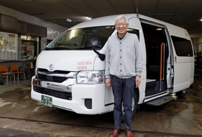 写真:送迎車両と「東ハイヤー」の松本年弘社長=せたな町