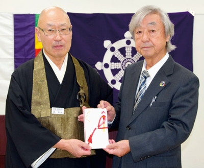 写真:長谷川会長(右)に善意を手渡した室蘭佛教会の西会長