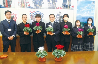 写真:シクラメンを牧野局長(中央)に手渡した壮瞥高校の生徒たち