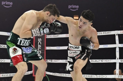 写真:プロ3戦目となったボクシング・スーパーフライ級10回戦で、カルロス・クアドラス(左)を攻める坪井智也=11月、トヨタアリーナ東京